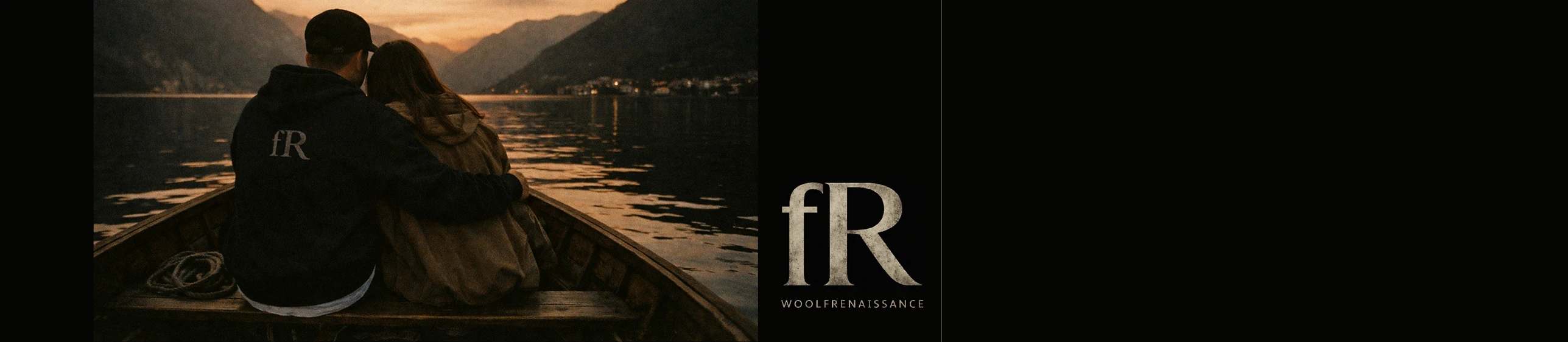 Couple embracing in a wooden boat on a mountain lake at sunset, with the WoolfRenaissance emblem on the man's jacket.